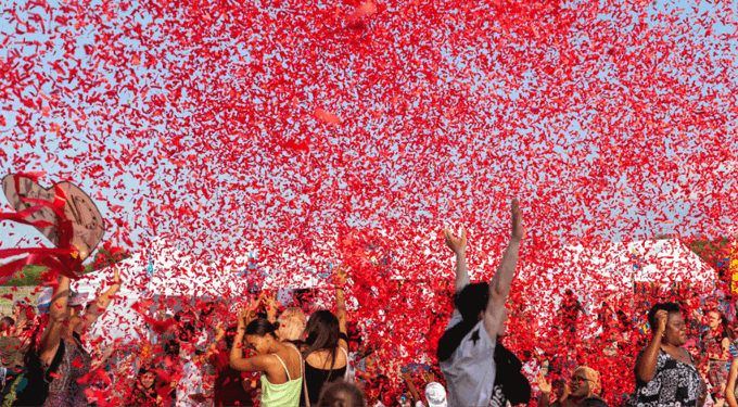 Group of people outside with red confetti in the air