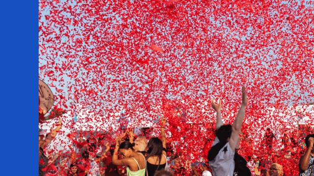Group of people outside with red confetti in the air