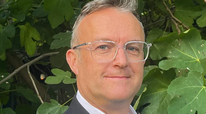 Headshot of man wearing glasses, smiling