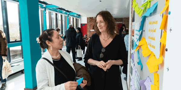 Two women standing and talking to each other