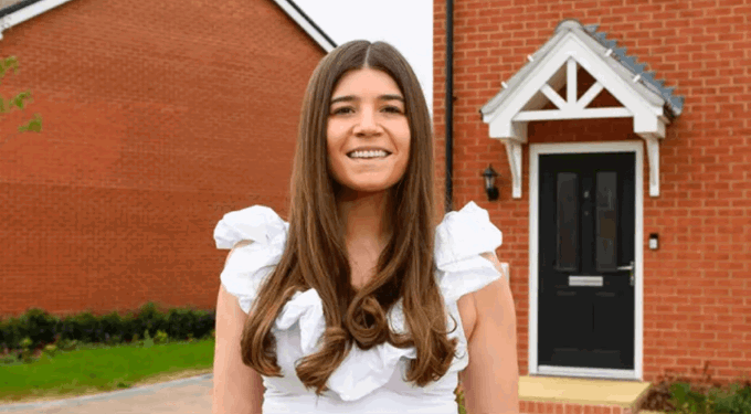 Woman smiling in front of a house