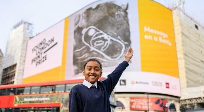 A Child Waving In Front Of Artwork